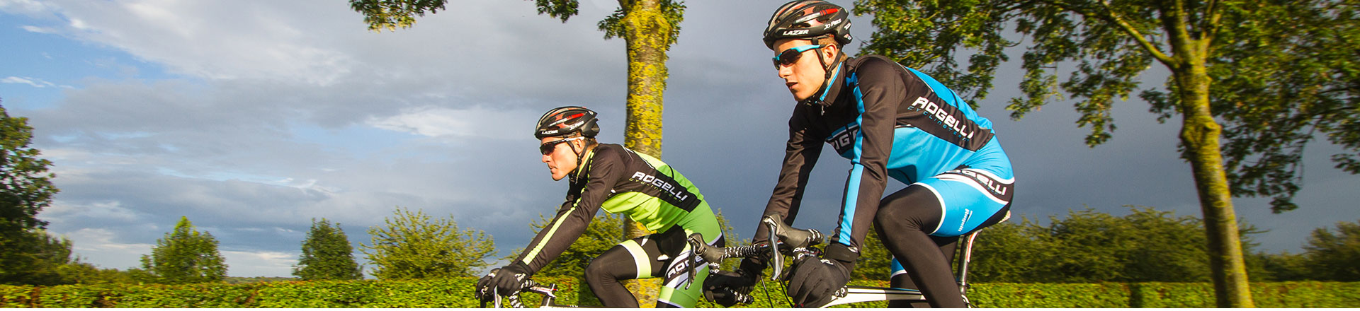 Twee wielrenners in een groen en een blauw shirt op een landelijke weg